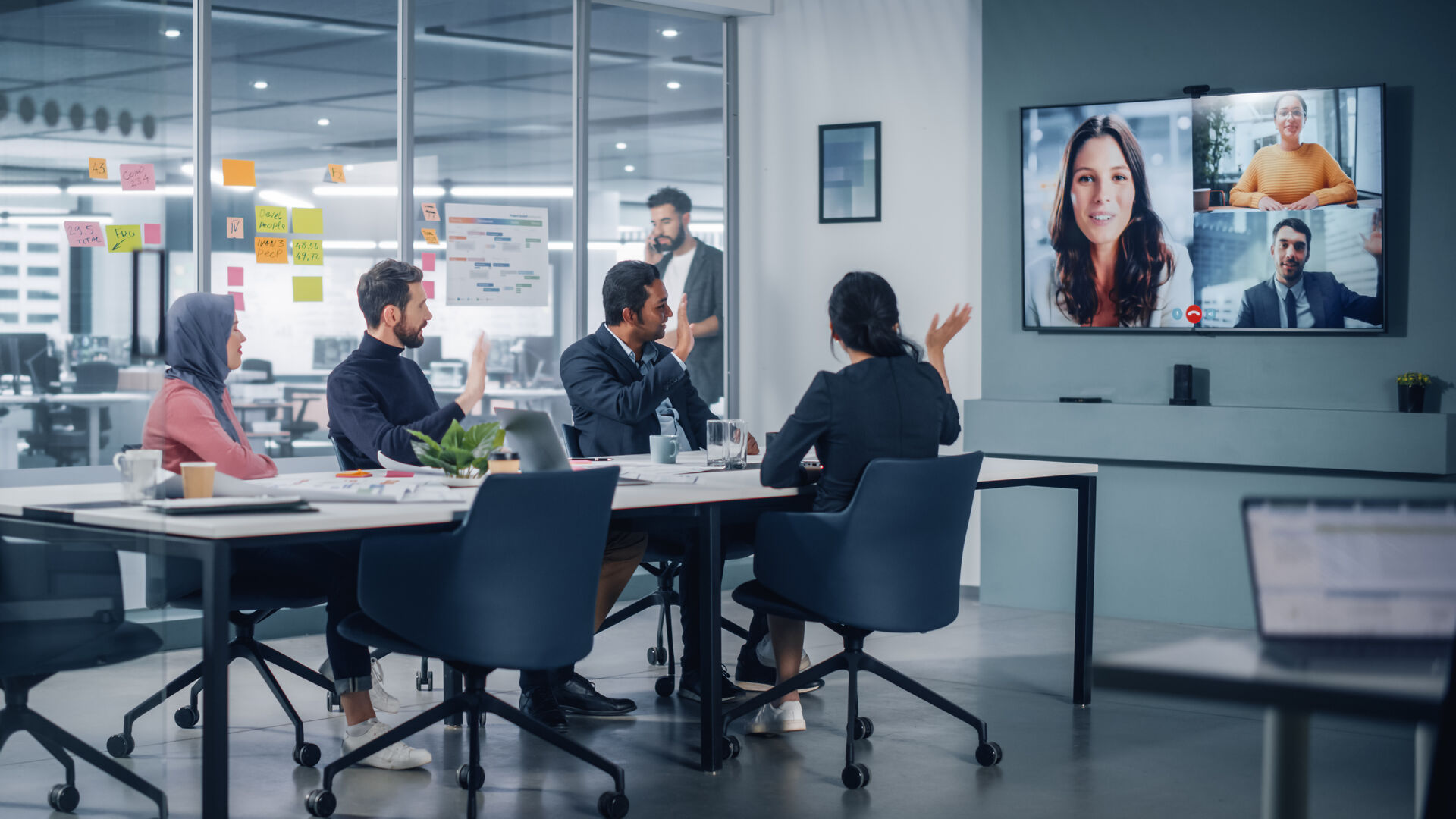 Leute sitzen in einen Büro und halten eine Videokonferenz