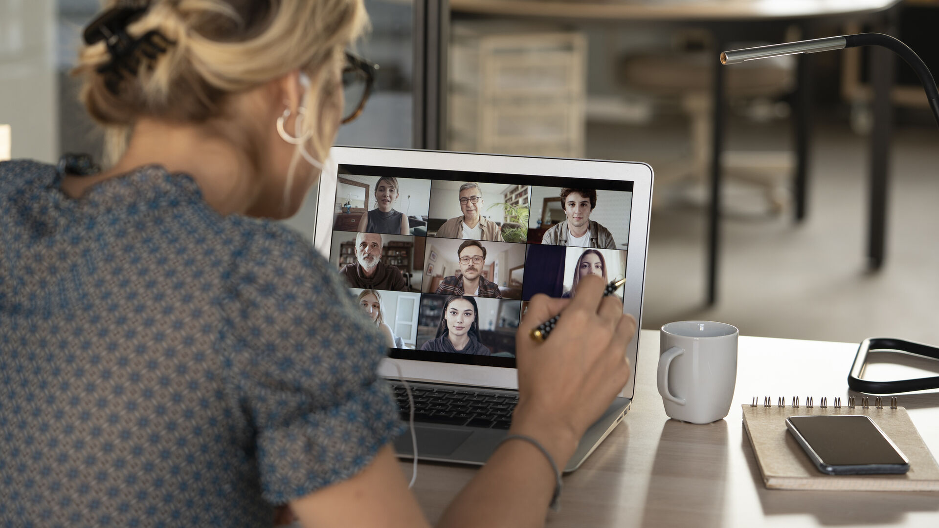 Eine Frau sitzt vor einem Laptop und hält ein Online-Meeting ab